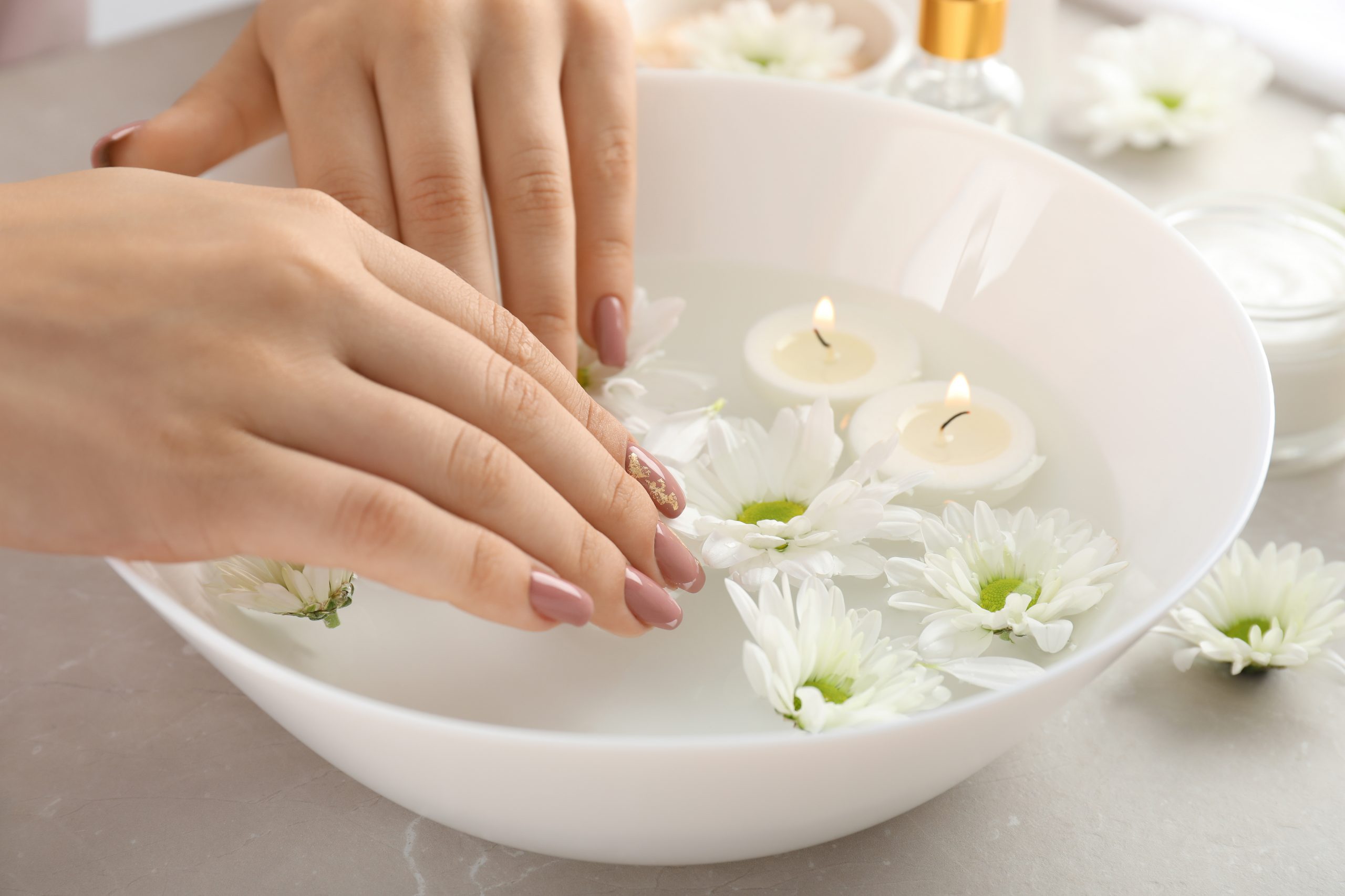 Concept of hand care with cosmetics on gray textured background